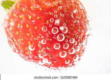 Ripe Strawberries Close-up In Sparkling Mineral Water, Macro Photo. The Concept Of Summer Refreshing Drinks, Cocktails, Organic Healthy Food.