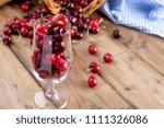 A lot of ripe and sweet cherries, on the table and in a glass, for traditional Belgian beer. Delicious red berries. Copy space,