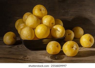 ripe sweet yellow plums in black ceramic bowl  close up