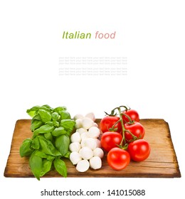 ripe tomatoes and mozzarella balls garnished with basil Italian food ingredients forming the italian flag on the old board isolated on white background