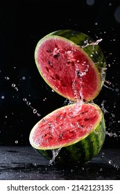 Ripe watermelon cut in half with water splash flying in the air