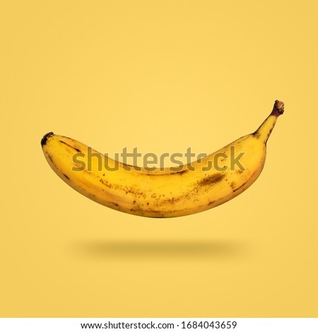 ripe yellow flying banana isolated on yellow background