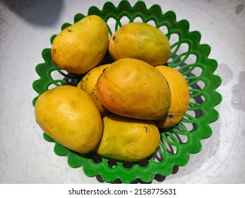 Ripe Yellow mango in basket, fresh yellow mango fruits in plastic green basket, yellow mangoes, sweet Mangoes, mango, mangos, yellow, orange summer fruits in basket, sweet Mangoes, summer fruits