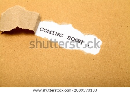 ripped brown paper revealing the words comming soon