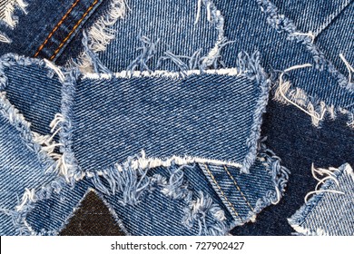Ripped denim patch on destroyed torn denim blue jeans. Double color denim jeans fashion background. Recycle old jeans denim concept