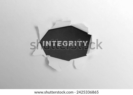 Ripped paper with integrity text on a black background. Reputation integrity concept