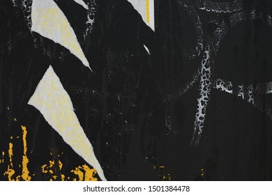 Ripped Street Poster Pieces On A Black Painted Plywood Wall