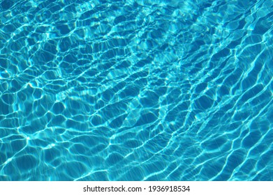 Ripple blue water in swimming pool with sun reflection