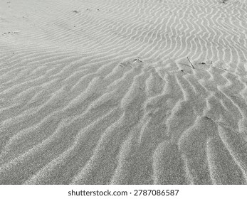 “Beautiful ripple patterns stretch across the soft sandy beach, shaped by the wind and waves. The delicate lines create a natural texture, giving the shoreline a peaceful and captivating appearance.”