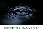 Ripple of water or water drop splash on black background. Abstract shape out of the water