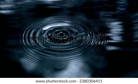 Ripple of water or water drop splash on black background. Abstract shape out of the water