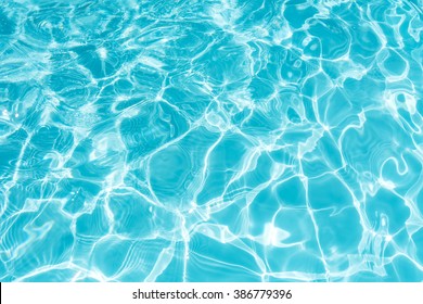 Ripple Water in swimming pool with sun reflection - Shutterstock ID 386779396