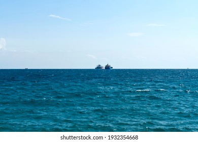 Rippled Aquamarine Sea Water Surface, Pale Blue Sky And Ships On The Horizon