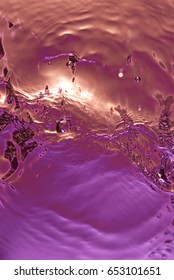 Rippled Water Purple Background. Colorful Liquid Spash Top View