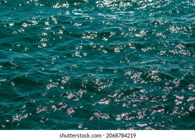 Rippled wavy aquamarine sea water surface glistening in sunlight  