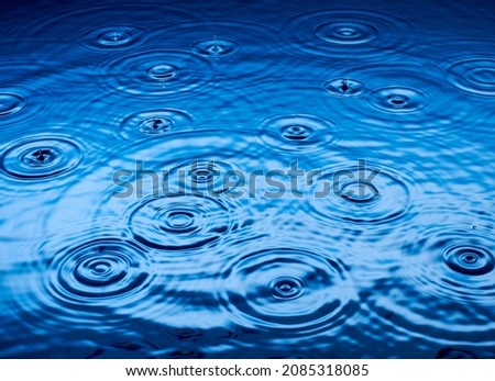 Ripples of raindrops in puddle