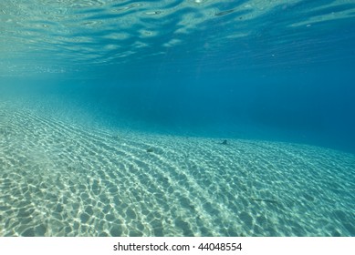 Ripples Sunlight On The Floor Of A Shallow Sandy Bay Reflected By A Calm Ocean Surface. Marsa Bareka, Ras Mohammed National Park, Red Sea, Egypt. MORE INFO: Wide Angle Scenic Shot In Clear Blue Water.