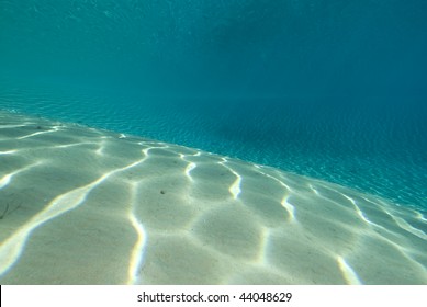 Ripples Sunlight On The Floor Of A Shallow Sandy Bay Reflected By A Calm Ocean Surface. Marsa Bareka, Ras Mohammed National Park, Red Sea, Egypt. MORE INFO: Wide Angle Scenic Shot In Clear Blue Water.