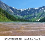 Rippling water on Avalanche Lake in this view out to a mountain range, including Little Matterhorn, with several cascading waterfalls fed by Sperry Glacier at Glacier National Park in Montana.