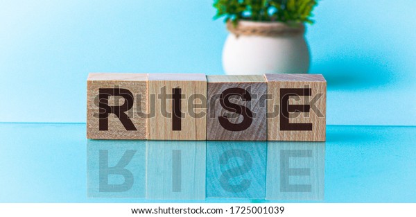 rise - word\
from wooden blocks with letters, to divide or use something with\
others share concept, blue\
background