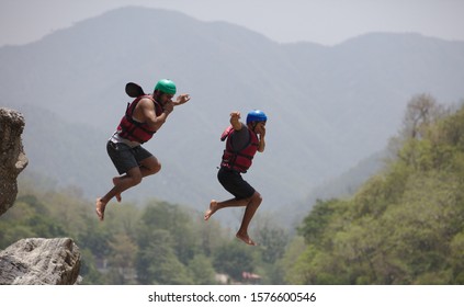 RISHIKESH, INDIA - JUNE 11, 2018 Two People Jumping From Cliff Into River