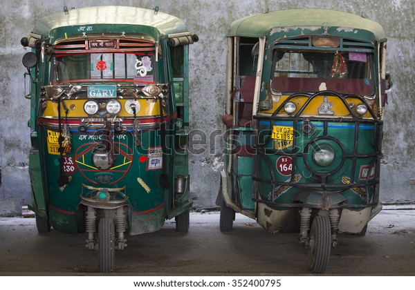 RISHIKESH, INDIA - OCTOBER\
19, 2014 : Auto rickshaw taxis on a road. These iconic taxis have\
recently been fitted with CNG powered engines in an effort to\
reduce pollution