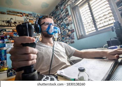 Rishon LeTsiyon, Israel - March 9, 2020: A cystic fibrosis patient wears an inhalation mask and holds a computer joystick