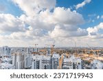 Rishon LeZion, Israel, September 20, 2023. Panorama of a large number of tower cranes, and development of new high-rise apartments against the backdrop of a blue sky and beautiful white clouds.