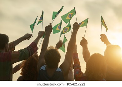 Rising Up Brazil Flags. Crowd Of People Holding Brazilian Flags, Back View.