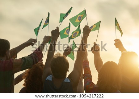 Rising up brazil flags. Crowd of people holding brazilian flags, back view.