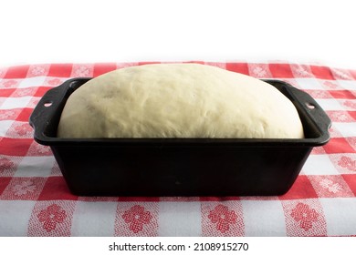 Rising Bread Dough In Black Vintage Pan Sitting On Red And White Gingham Tablecloth