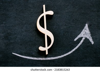 Rising Dollar.growth Of The Exchange Rate.rise Of The Dollar.Dollar Sign And Up Arrow On Black Chalkboard Background.Economic Stability In The Dollar Zone