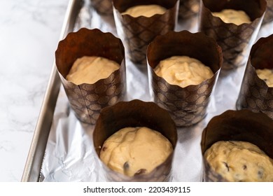 Rising dough in paper liners to bake mini Easter bread kulich. - Shutterstock ID 2203439115
