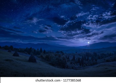 Rising of the full moon in a mountain valley with stars in a cloudy night sky. Dramatic and picturesque scene. Carpathians, Ukraine. Beautiful world. - Powered by Shutterstock