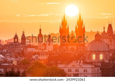 The rising sun in between towers of the Church of Our Lady before Tyn in UNESCO site Prague.