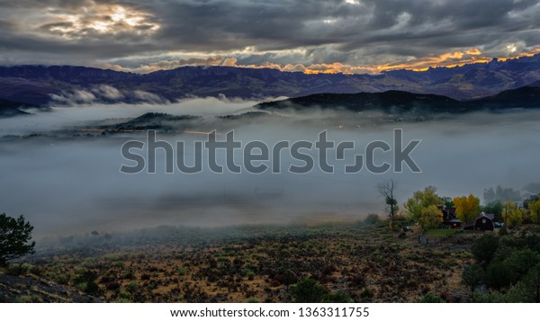Rising sun outlining the ridge with autumn\
mist covering Ridgway\
Colorado	