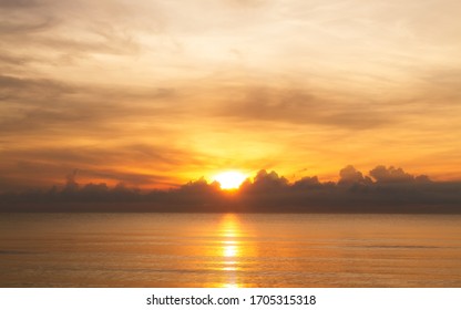 The Rising Sun Over Clouds In The Sea. The Morning Light With A Beautiful Orange Sky.