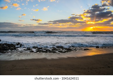 The Rising Sun Reflection On A Rocky Florida Beach