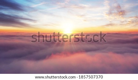 Rising sunset above the clouds, airplane view above the sky