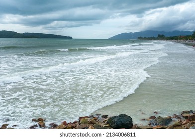 Rising Tide With Beachgoers On A Cloudy Evening 