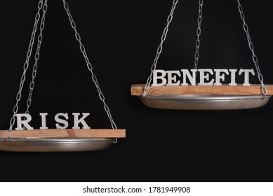 Risk And Benefit Reward Concept. Scales On Black Background Close Up.