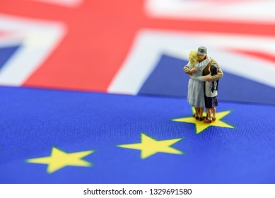 Risk of Brexit or the withdrawal of the United Kingdom from the European Union : Miniature family hug each other on EU and UK flags, depict risk & impact on bilateral UK relation e.g economic, finance