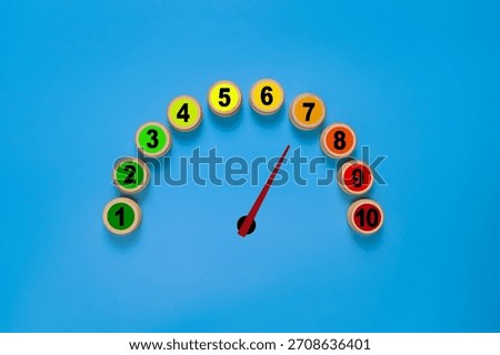 risk level meter indicator from low to high with 1 to 10 scale numbers on wooden blocks. isolated on blue background. concept of risk management