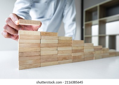 Risiko, um das Geschäftswachstum Konzept mit Holzblöcken, Hand der Geschäftsmann hat die Anhäufung und stapeln einen Holzblock, Alternative Risikokonzept, Plan und Strategie in der Wirtschaft.