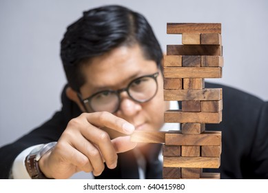 Risk Management, Strategy Concept: Young Asian Businessman With Brain Game: Jenga Game