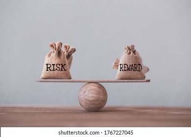 Risiko- und Belohnungsbeutel auf einer Basis-Waage in gleicher Position auf Holztisch. Risikomanagementkonzept, in dem die Anleger die erwartete Rendite einer Anlage anhand eines Risikobelohnungskoeffizienten vergleichen