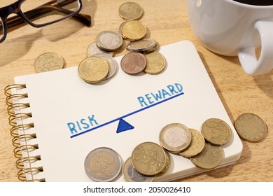 Risk Reward Concept. Drawing On Notepad And Coins On Desk