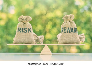 Risk reward ratio / risk management concept : Risk and reward bags on a basic balance scale in equal position, depicts investors use a risk reward ratio to compare the expected return of an investment