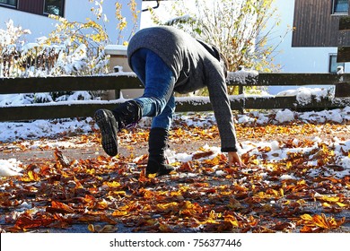 Risk Of Slipping In Autumn And Winter. A Woman Slipped On Wet, Smooth Leaves
