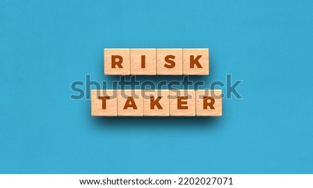 Risk Taker - word written on wooden blocks with blue background